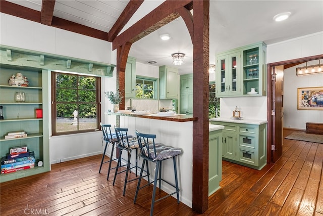 10 Strawberry Ln, San Juan Capistrano, CA 92675 - kitchen featuring green cabinets, dark wood-type flooring, a kitchen bar, glass insert cabinets, and beamed ceiling