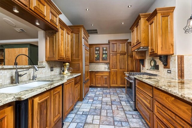 30026 Santiago Rd, Temecula, CA 92592 - kitchen with stainless steel range with gas stovetop, brown cabinetry, backsplash, light stone countertops, and recessed lighting
