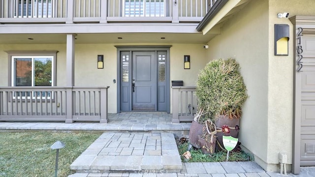 21822 Seacrest Ln, Huntington Beach, CA 92646 - view of exterior entry featuring stucco siding, a porch, and a balcony