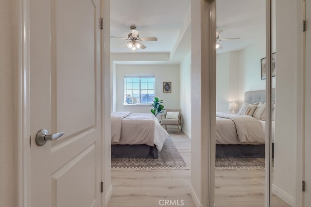 3120 Sepulveda Blvd Unit 312, Torrance, CA 90505 - bedroom featuring a ceiling fan, a tray ceiling, and light wood-type flooring