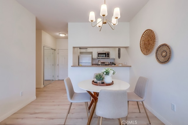 3120 Sepulveda Blvd Unit 312, Torrance, CA 90505 - dining area with baseboards, a chandelier, and light wood-style floors