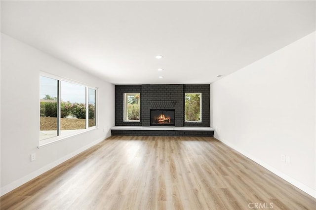 27130 Blue Hill Dr, Menifee, CA 92586 - unfurnished living room featuring light wood-style floors, baseboards, recessed lighting, and a fireplace