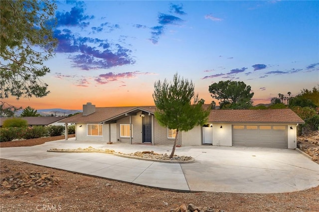 27130 Blue Hill Dr, Menifee, CA 92586 - view of front of property with driveway, an attached garage, stucco siding, and a chimney
