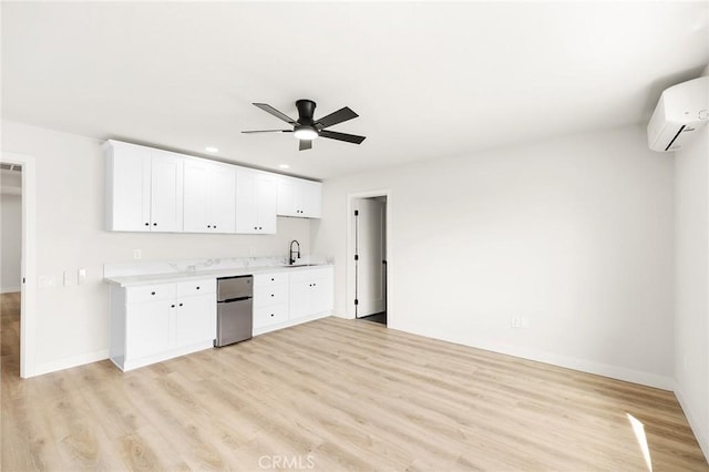 27130 Blue Hill Dr, Menifee, CA 92586 - kitchen featuring freestanding refrigerator, light countertops, a wall unit AC, light wood finished floors, and ceiling fan