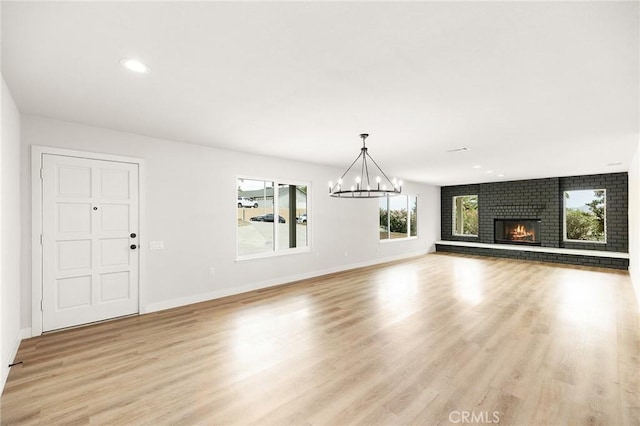 27130 Blue Hill Dr, Menifee, CA 92586 - unfurnished living room with a chandelier, light wood finished floors, a fireplace, baseboards, and recessed lighting