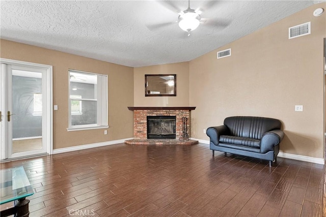 11941 9th Ave, Hesperia, CA 92345 - sitting room with dark wood finished floors, a textured ceiling, a ceiling fan, a fireplace, and baseboards