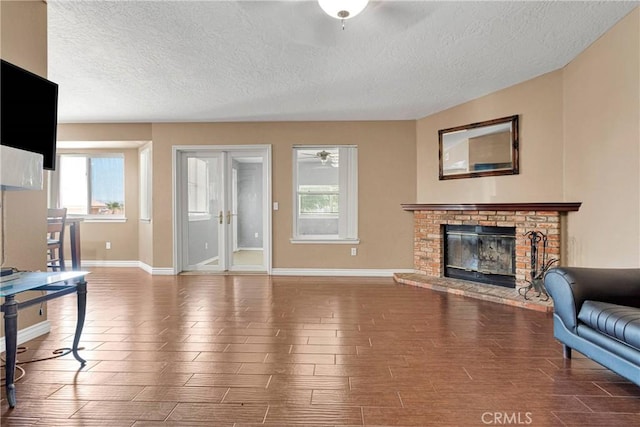 11941 9th Ave, Hesperia, CA 92345 - living room featuring a brick fireplace, a textured ceiling, ceiling fan, wood finished floors, and baseboards