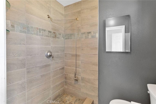 11941 9th Ave, Hesperia, CA 92345 - bathroom with tiled shower, toilet, and a textured wall