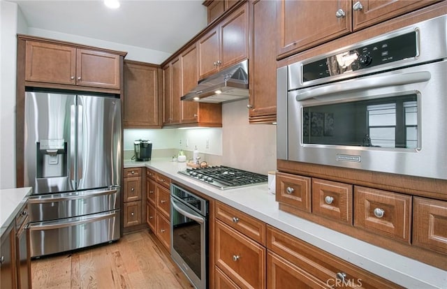 67 Galan St, Rancho Mission Viejo, CA 92694 - kitchen featuring appliances with stainless steel finishes, under cabinet range hood, light wood-type flooring, and light countertops