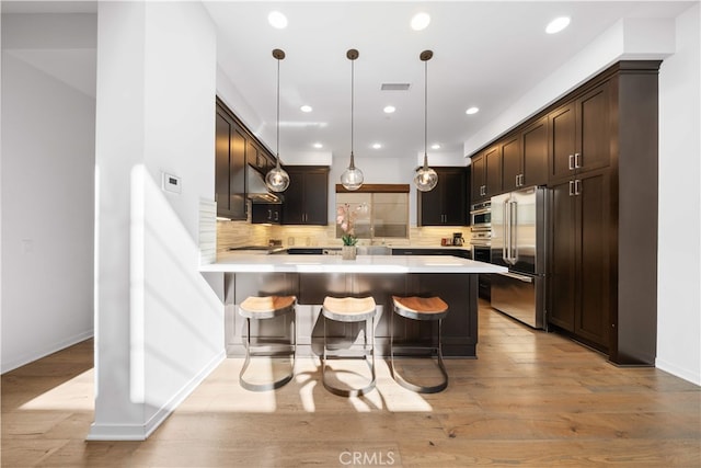 105 Newall, Irvine, CA 92618 - kitchen with high quality fridge, a peninsula, dark brown cabinets, backsplash, and light countertops