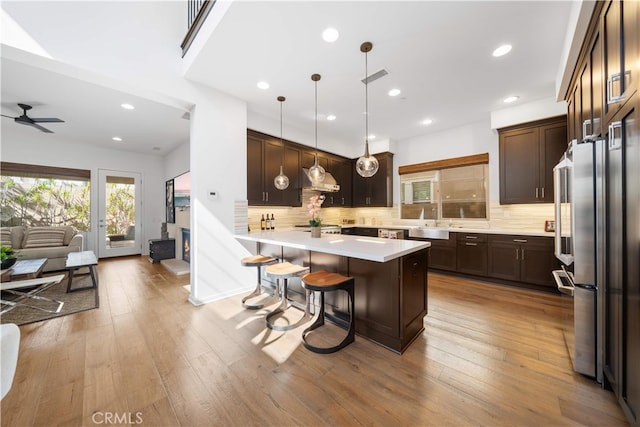 105 Newall, Irvine, CA 92618 - kitchen featuring open floor plan, a kitchen bar, dark brown cabinetry, light countertops, and a ceiling fan