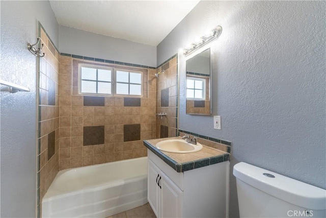 11314 Mariposa Rd, Hesperia, CA 92345 - full bathroom featuring a textured wall, toilet, vanity, tub / shower combination, and tile patterned flooring