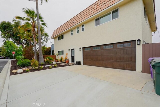 318 S Lucia Ave, Redondo Beach, CA 90277 - view of side of home with a garage, stucco siding, a tile roof, and concrete driveway
