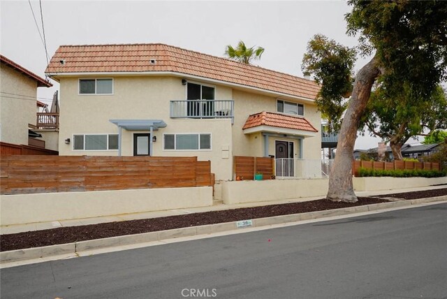 318 S Lucia Ave, Redondo Beach, CA 90277 - view of front of home featuring a fenced front yard, a tiled roof, stucco siding, and a balcony