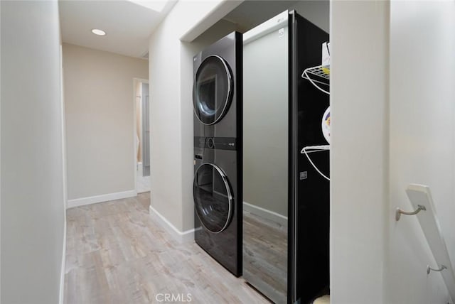 318 S Lucia Ave, Redondo Beach, CA 90277 - laundry room featuring stacked washing machine and dryer, light wood-style floors, and baseboards