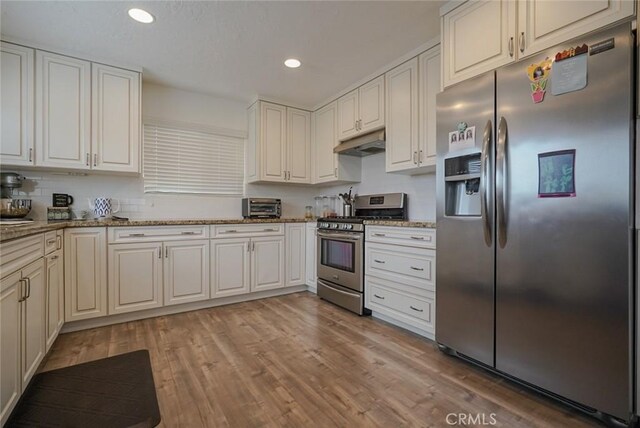 318 S Lucia Ave, Redondo Beach, CA 90277 - kitchen with appliances with stainless steel finishes, under cabinet range hood, recessed lighting, light wood-type flooring, and light stone counters