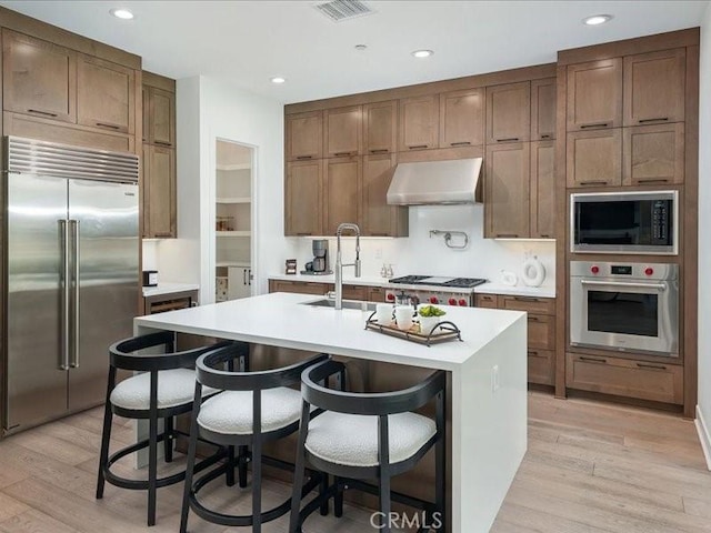 18814 Annmae Pl, Saugus, CA 91350 - kitchen featuring built in appliances, extractor fan, light wood-style flooring, light countertops, and recessed lighting