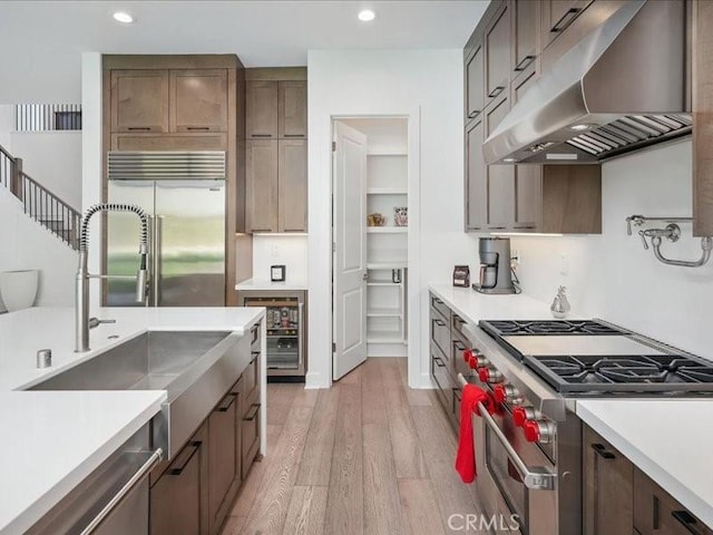 18814 Annmae Pl, Saugus, CA 91350 - kitchen with exhaust hood, high quality appliances, light wood-style floors, light countertops, and wine cooler