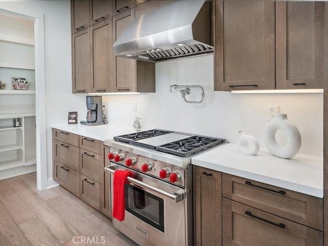 18814 Annmae Pl, Saugus, CA 91350 - kitchen with designer range, wall chimney exhaust hood, light wood-type flooring, light countertops, and built in shelves