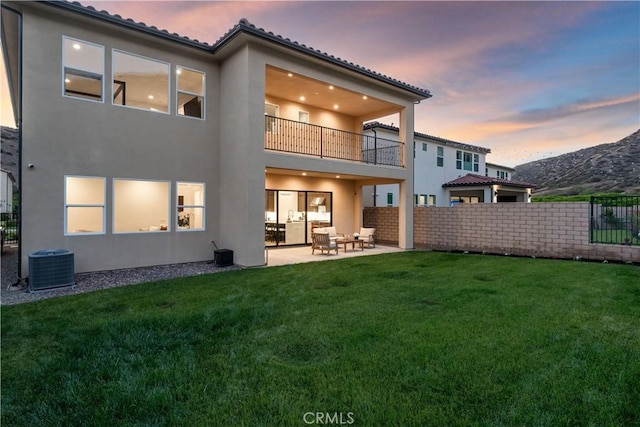 18814 Annmae Pl, Saugus, CA 91350 - back of house at dusk with a balcony, stucco siding, a patio, and a mountain view