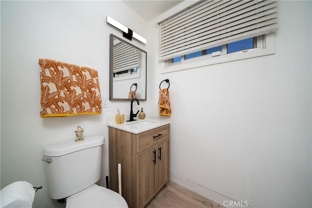 9966 Vernon Ave, Montclair, CA 91763 - bathroom featuring vanity, toilet, wood finished floors, and baseboards