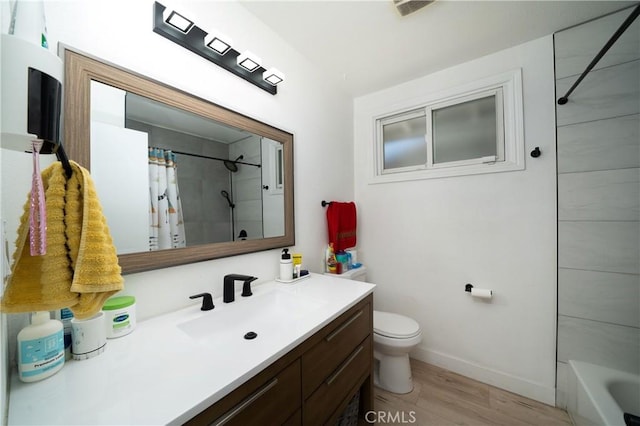9966 Vernon Ave, Montclair, CA 91763 - bathroom featuring vanity, toilet, wood finished floors, and baseboards