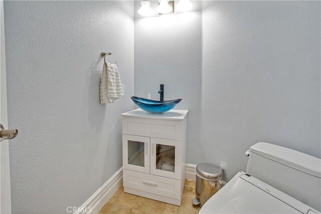 25792 Maple View Dr, Laguna Hills, CA 92653 - half bathroom with a sink, toilet, baseboards, and a textured wall