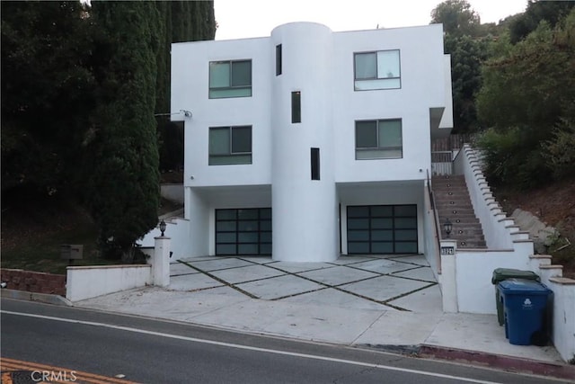 3921 Beverly Glen Blvd, Sherman Oaks, CA 91423 - art deco house with stucco siding, stairway, an attached garage, and driveway