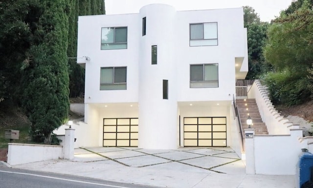 3921 Beverly Glen Blvd, Sherman Oaks, CA 91423 - art deco house featuring stucco siding, an attached garage, concrete driveway, and stairs