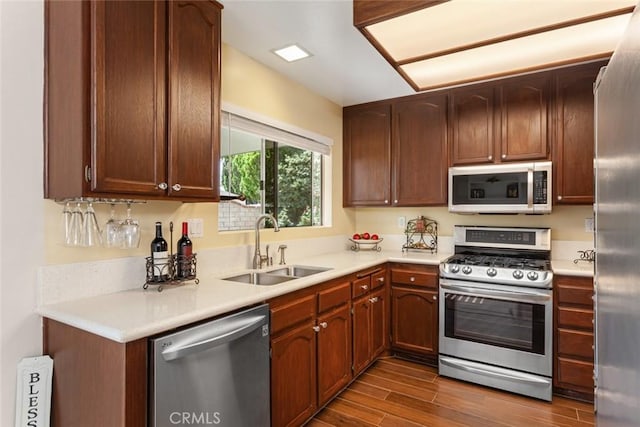 28015 Tupelo Ridge Dr, Valencia, CA 91354 - kitchen featuring appliances with stainless steel finishes, a sink, dark wood-style flooring, and light countertops