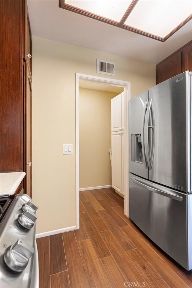 28015 Tupelo Ridge Dr, Valencia, CA 91354 - kitchen with stainless steel fridge with ice dispenser, range, dark wood-style flooring, light countertops, and baseboards
