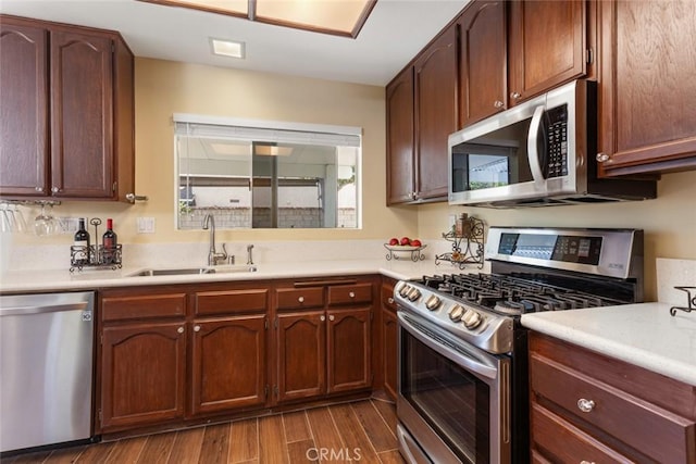 28015 Tupelo Ridge Dr, Valencia, CA 91354 - kitchen with stainless steel appliances, a sink, dark wood-style flooring, and light countertops
