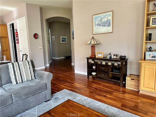 5836 Indian Canyon Dr, Banning, CA 92220 - living room with arched walkways, dark wood-type flooring, and baseboards
