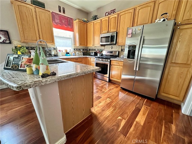5836 Indian Canyon Dr, Banning, CA 92220 - kitchen featuring stainless steel appliances, a peninsula, backsplash, and wood finished floors