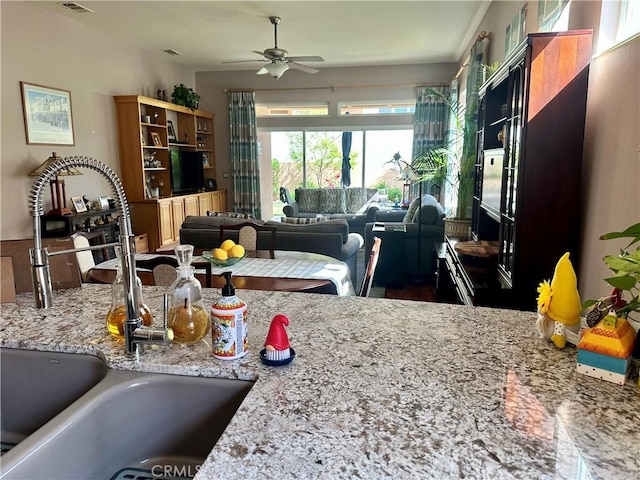 5836 Indian Canyon Dr, Banning, CA 92220 - kitchen featuring a sink, ceiling fan, light stone counters, and open floor plan