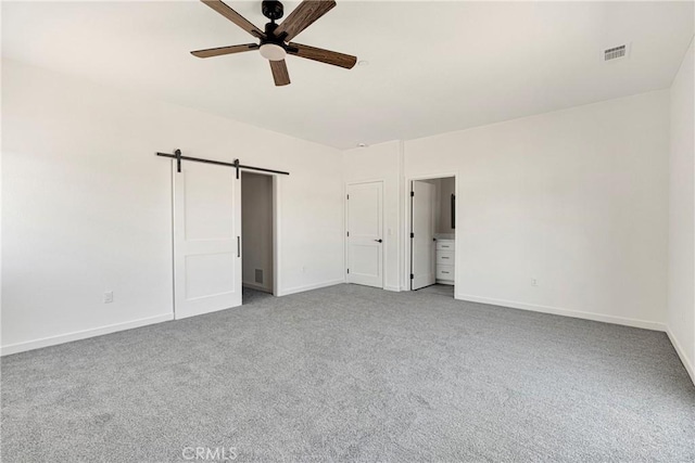 22212 Lone Eagle Rd, Apple Valley, CA 92308 - unfurnished bedroom with light colored carpet, a barn door, and a ceiling fan