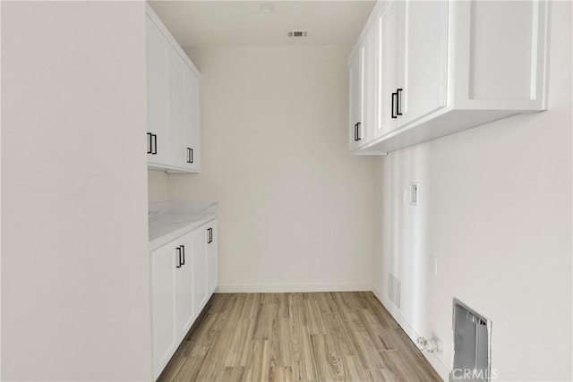 22212 Lone Eagle Rd, Apple Valley, CA 92308 - laundry room featuring cabinet space, light wood-style floors, and washer hookup