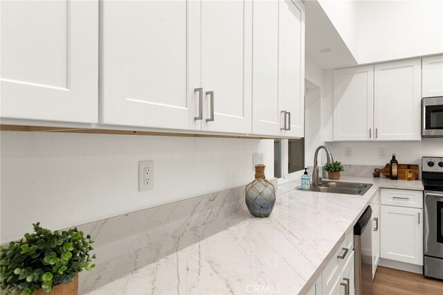 12573 Brickellia St, San Diego, CA 92129 - kitchen featuring a sink, stainless steel appliances, white cabinets, and light stone countertops