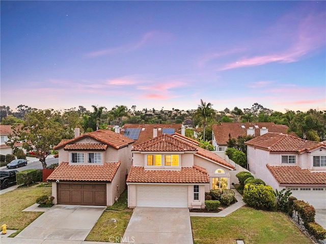 12573 Brickellia St, San Diego, CA 92129 - mediterranean / spanish-style home with an attached garage, driveway, a front yard, solar panels, and stucco siding