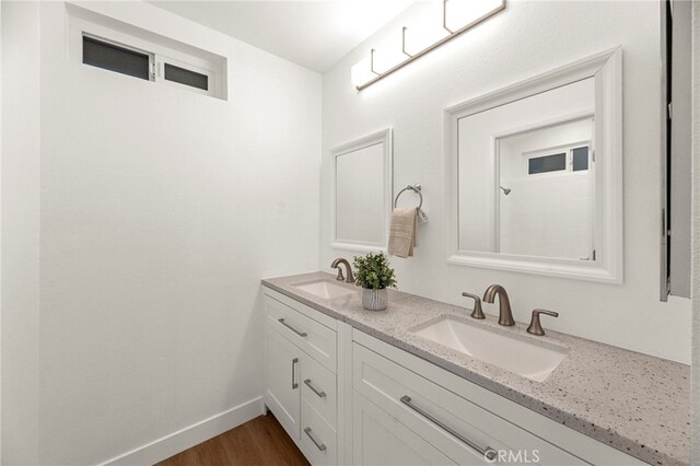 12573 Brickellia St, San Diego, CA 92129 - full bathroom featuring double vanity, wood finished floors, and baseboards
