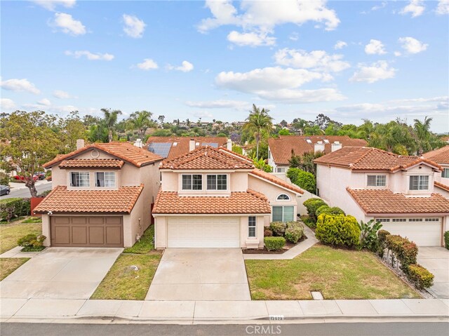12573 Brickellia St, San Diego, CA 92129 - mediterranean / spanish-style home with stucco siding, roof mounted solar panels, a tiled roof, a front lawn, and a residential view