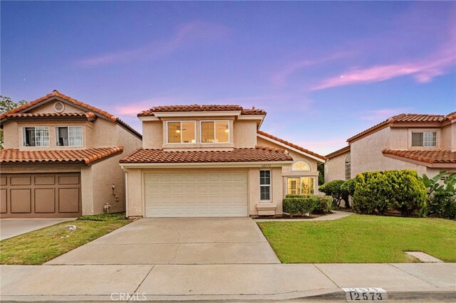 12573 Brickellia St, San Diego, CA 92129 - mediterranean / spanish-style house with driveway, an attached garage, a yard, and a tile roof