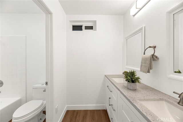 12573 Brickellia St, San Diego, CA 92129 - full bathroom with double vanity, toilet, wood finished floors, and baseboards
