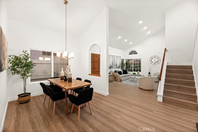 12573 Brickellia St, San Diego, CA 92129 - dining room featuring stairway, high vaulted ceiling, baseboards, wood finished floors, and a chandelier