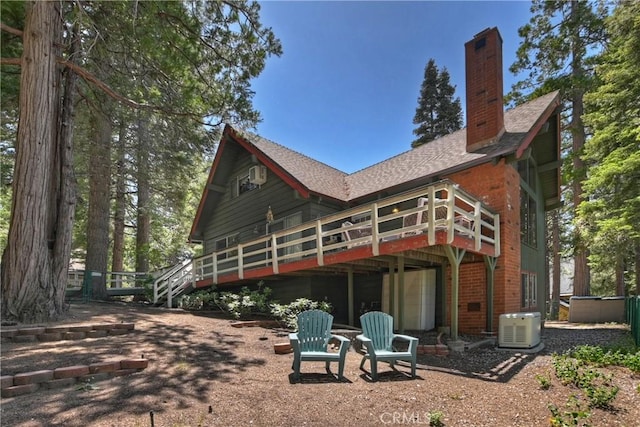 535 Pioneer Rd, Lake Arrowhead, CA 92352 - back of house with a wooden deck, a chimney, a shingled roof, and brick siding