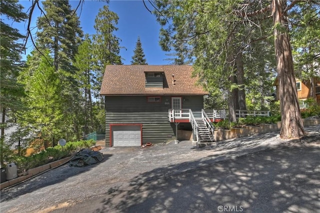 535 Pioneer Rd, Lake Arrowhead, CA 92352 - view of front of home featuring stairs, dirt driveway, a wooden deck, and a garage