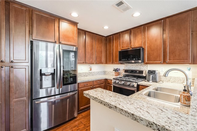 28426 Herrera St, Valencia, CA 91354 - kitchen with appliances with stainless steel finishes, a sink, dark wood-style flooring, recessed lighting, and light stone countertops
