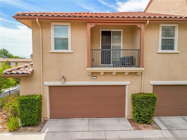 28426 Herrera St, Valencia, CA 91354 - view of front of home with an attached garage, stucco siding, a tiled roof, a balcony, and driveway