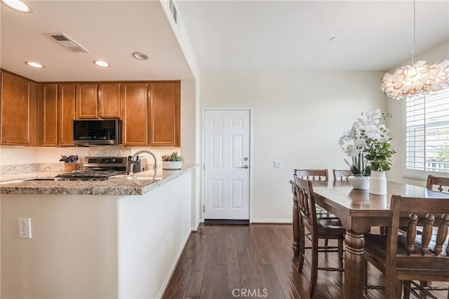 28426 Herrera St, Valencia, CA 91354 - kitchen featuring stainless steel stove, dark wood-style floors, brown cabinetry, baseboards, and light stone counters