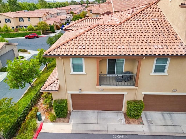 28426 Herrera St, Valencia, CA 91354 - view of front of home with a garage, a residential view, driveway, a tile roof, and stucco siding